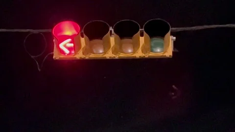 Flashing red stop lights arrow at night in Austin, Texas on 9-28-2025 Stock Footage 317937899