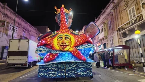 Flashing starfish-shaped float from behind at the Gozo Carnival in Victoria Stock Footage 305479437