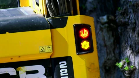 Flashing yellow tail light with red light on black and yellow excavator close up Stock Footage 324766692