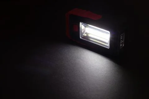 Flashlight and a beam of light in darkness. A modern led lamp with bright pro Fotos Stock