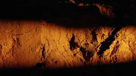 Flashlight beam moving across a cave wall revealing textures Stock Footage 341294570