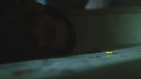 Flashlight beam shining on a dead man lying near a bullet case in a dark room Stock Footage 275614266