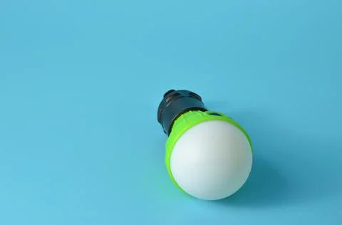 Flashlight in the form of a light bulb on a blue background. Stock Photos