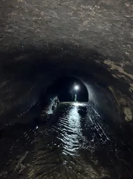 Flashlight inside the cave. Catacomb labyrinth. Stock Photos