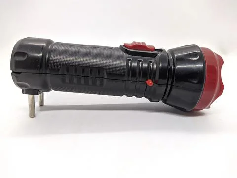 Flashlight with a plug that charges from an outlet on a white background. 스톡 사진