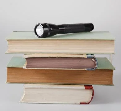 Flashlight on stack of books Foto stock