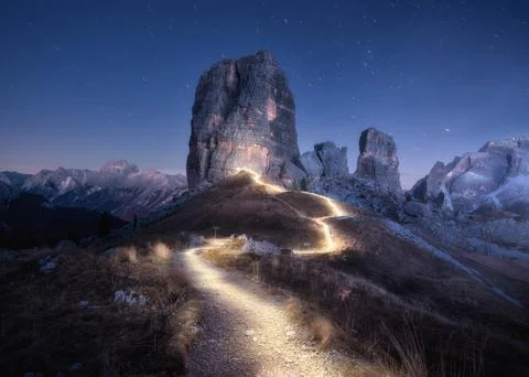 Flashlight trails on mountain path against high rocks at night Stock Photos