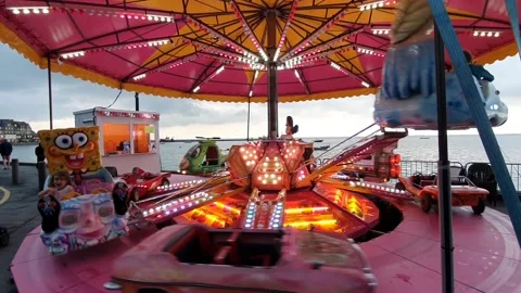 A flashy carousel during a fair with the sea in the background Stock Footage 158997617