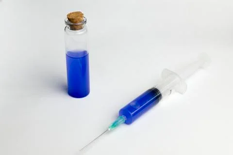 The flask and syringe with blue solution in laboratory science. Stock Photos