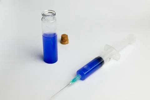 The flask and syringe with blue solution in laboratory science. Stock-Fotos