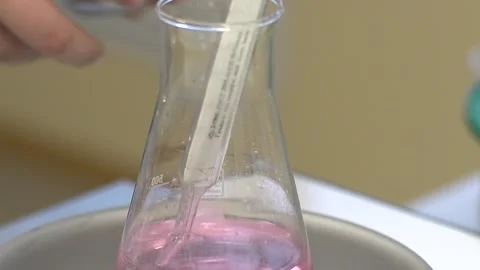 Flask with pink liquid and thermometer- 库存影片 147908124