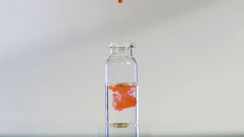The flask rotates in the center and the red substance slowly dissolves. Stock Footage 156994937