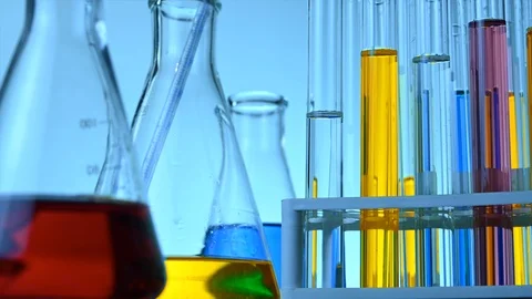 Flasks and test tubes stand in a laboratory with colored chemical liquids Stock Footage 121635190