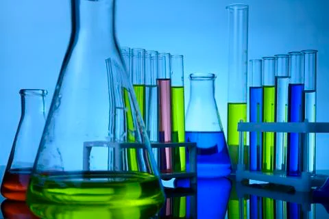 Flasks and test tubes stand in a laboratory with colored chemical liquids Stock Photos