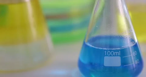 Flasks with blue and yellow liquid stand... | Stock Video | Pond5
