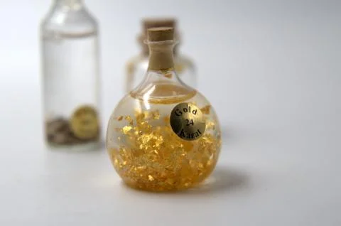 Flasks containing gold samples of varying caliber. Stock Photos