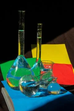 Flasks with liquid on a colorful background with light on it 写真素材