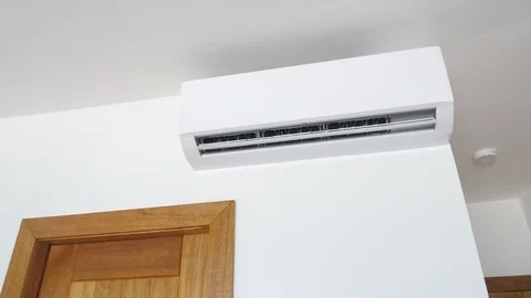 Flat air conditioner on white wall in room interior. Man pushing button on Stock Footage 118291625