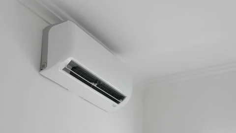 Flat air conditioner on white wall in room interior. Man pushing button on Stock Footage 162163819