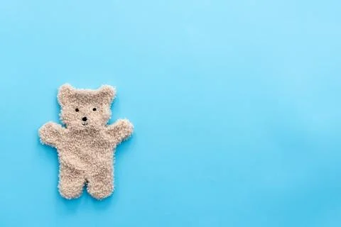 Flat bear toy on blue background with copy space. Baby concept Stock Photos