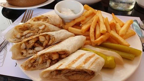 Flat bread with chopped chicken. Fried potatoes, pickles. 库存照片