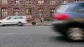 Flat city street view, traffic cars drive pass brick building HD Footage