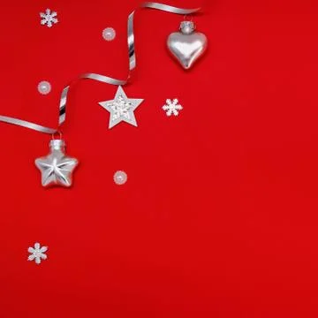 Flat composition of Christmas decorations in silver on a red background. Stock Photos