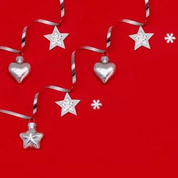 Flat composition of Christmas decorations in silver on a red background. Stock Photos