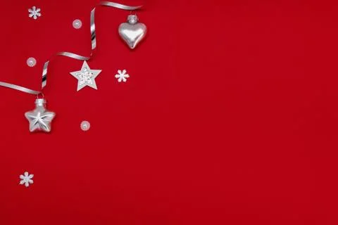Flat composition of Christmas decorations in silver on a red background. Stock Photos