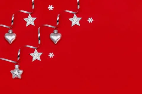 Flat composition of Christmas decorations in silver on a red background. Stock Photos