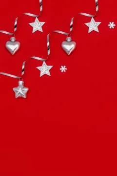Flat composition of Christmas decorations in silver on a red background. Stock Photos