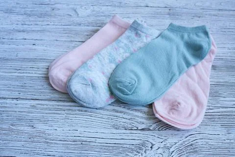 Flat composition with cute socks on white wooden background. Stock Photos
