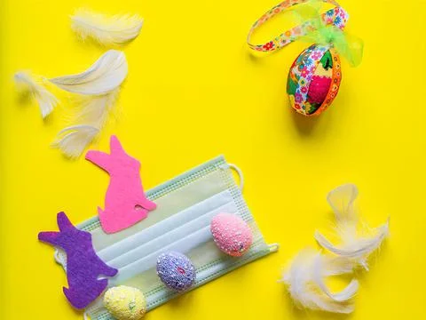 Flat composition easter symbol eggs and easter bunny with protective mask Stock Photos