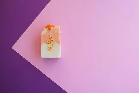 Flat composition with natural soap on pink and purple background. Stock Photos