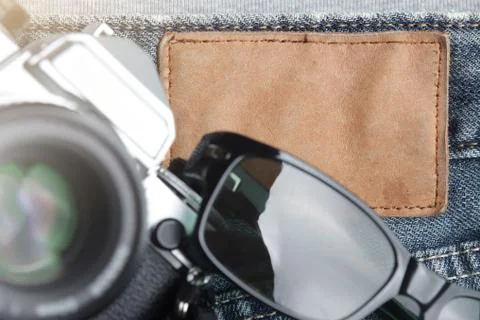Flat composition of vintage SLR camera and sunglasses on worn jeans Stock Photos