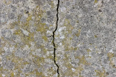 A flat concrete textured surface with a large crack in the middle Stock Photos