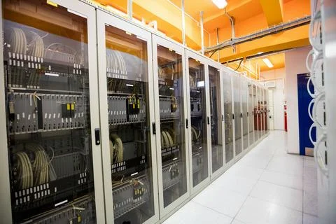Flat design cabinets are lining data center corridor, showing patch cables, Stock Photos