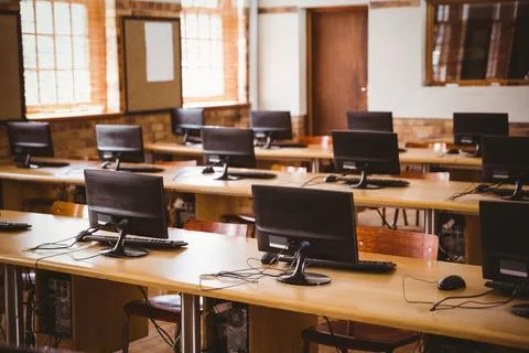 Flat design computer workstation on wood desk is sitting in school lab with Stock Photos