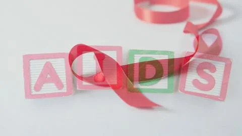 Flat design is showing pastel blocks spelling AIDS with ribbon in health Stock Photos