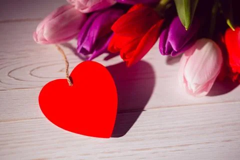 Flat design showing red heart-shaped twine-tied tag on whitewashed tabletop with Stock Illustration