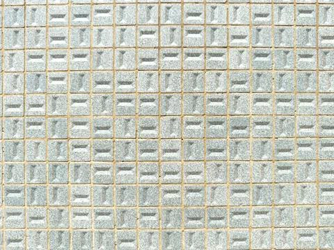 A flat front view of a geometric wall pattern featuring small light blue te.. Stock Photos