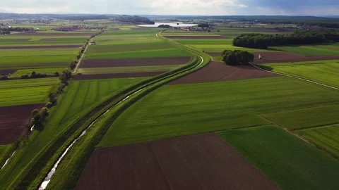 Flat Green fileds with Stream towards Lake Stock Footage 143172383