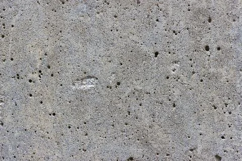 A flat grey concrete textured surface covered in lots of air bubbles Stock Photos