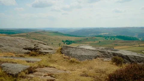 Flat gritstone rock platform above open countryside and rolling hills, slide Stock Footage 341569148