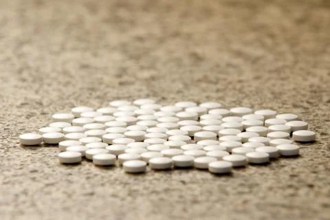 Flat group of generic white pills on hard surface Stock Photos