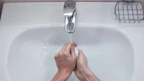 Flat. The guy washes his hands in the bathroom. Stockbeeldmateriaal 151920443