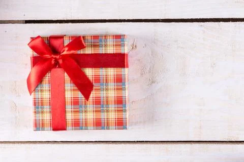Flat lay above box with red bow and wooden planks background Stock Photos