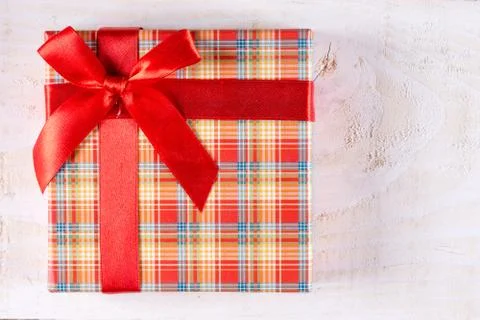 Flat lay above box with red bow and wooden planks background Stock Photos