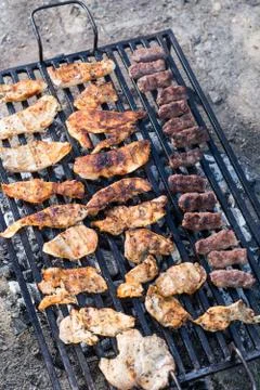 Flat lay above chicken white breast meat on the barbecue grill with kebabs Foto stock