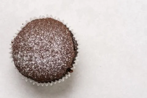 Flat lay above chocolate cup cake with powdered sugar and copy space Stock Photos